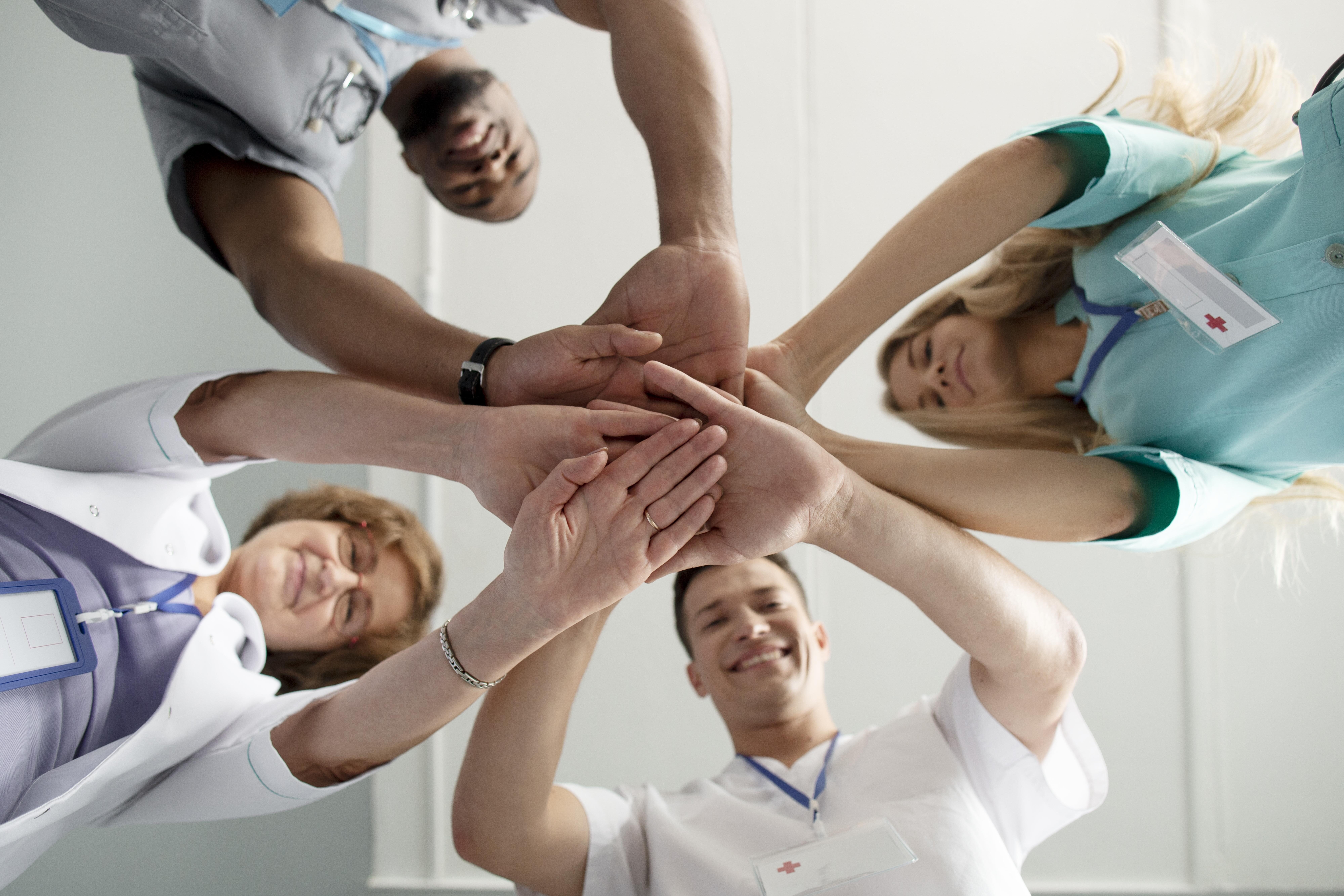 Dees personnels hospitaliers joignent leurs mains en signe de cohésion