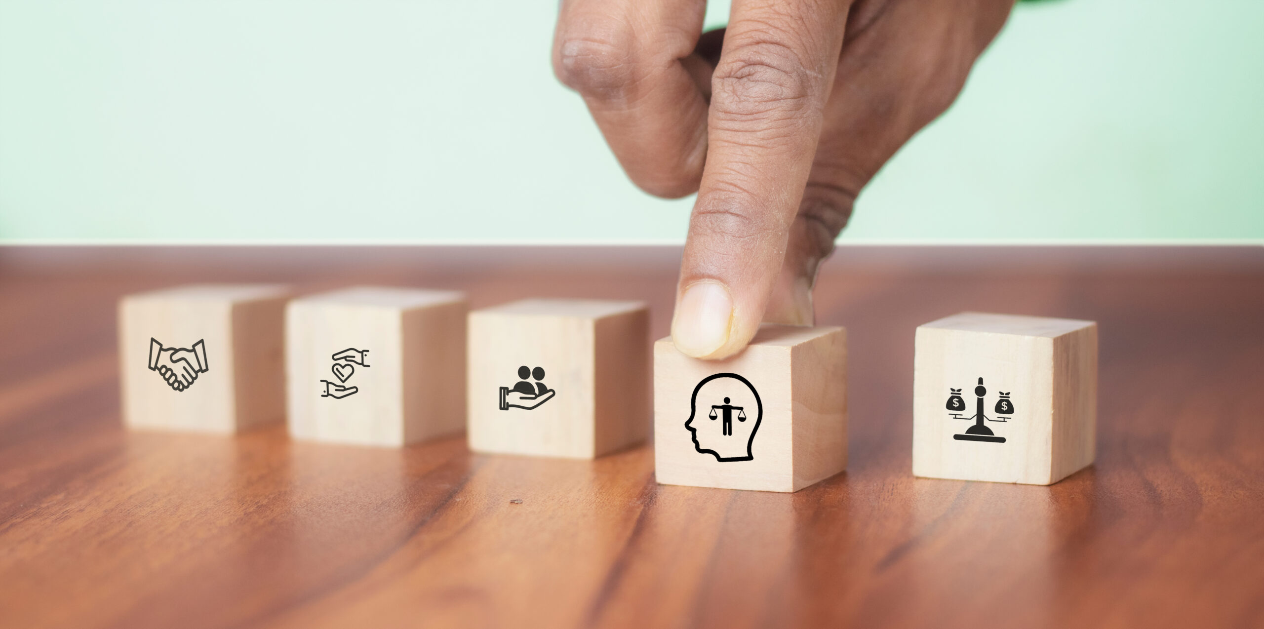 Un doigt posé sur un cube avec un pictogramme représentant une tête