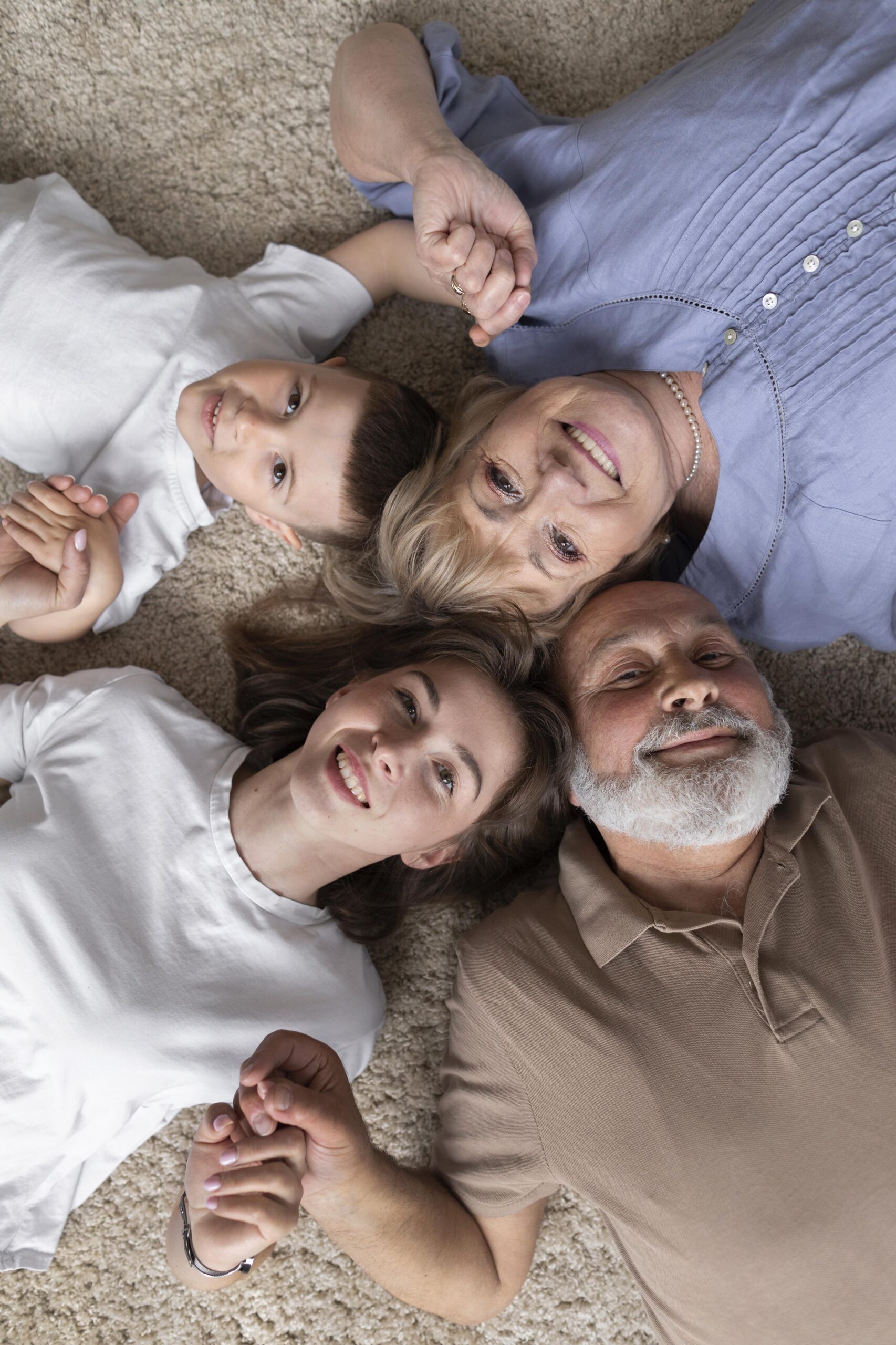 Des grands parents et leurs petits enfants regarde le ciel allongés sur le dos