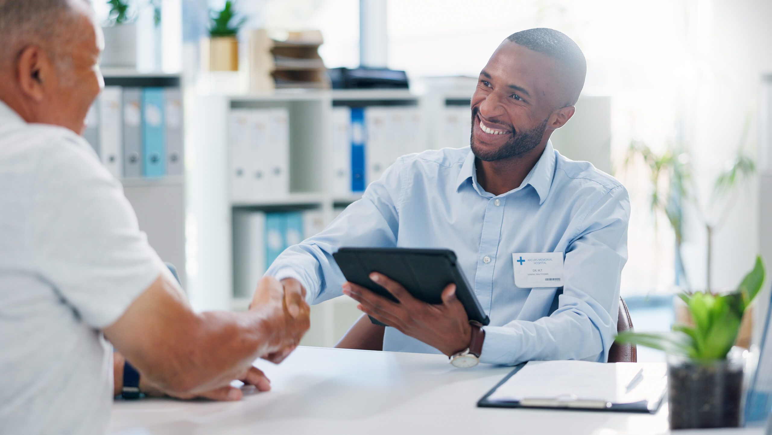 Un homme sert la main de son patient plus âgé