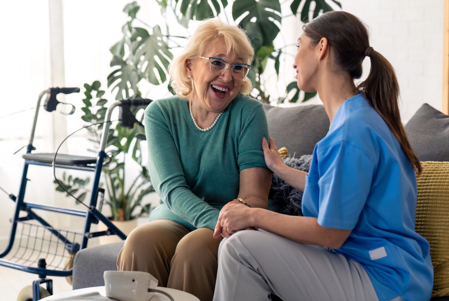 Une femme âgé rit en discutant avec une infirmière
